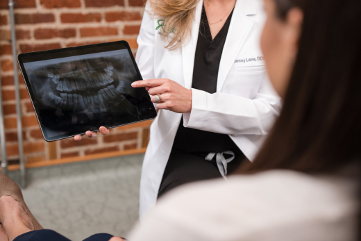 An oral surgeon showing a close up of a wisdom teeth x-ray to patient.